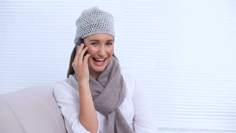 young woman with hat and scarf calling someone