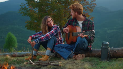 closeup couple travelers relax on mountains trip. campers enjoy romantic music.