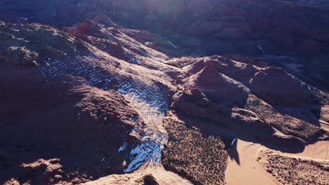 Rocky-cliffs-with-snow-on-slopes-on-sunny-day-in-valley