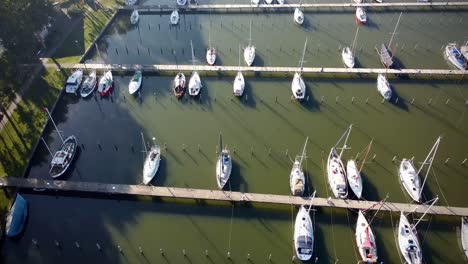 drone view over docked boats and ships in a harbor on a sunny day