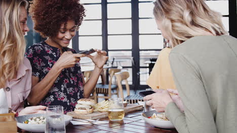 Vier-Freundinnen-Fotografieren-Essen-Und-Posieren-Für-Ein-Selfie-Im-Restaurant,-Bevor-Sie-Essen