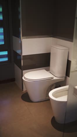 contemporary hotel bathroom featuring a clean white toilet against dark accent walls, showcasing a sleek and modern design