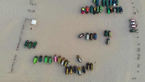 aerial of cars parked in the desert of huacachina peru