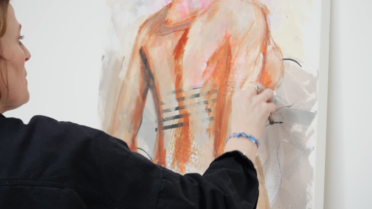 여성 예술가 는 홈 스튜디오 에 서서 캔버스 에 그림 을 그리고 있다