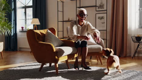 a happy person playing with their dog in a sunny living room