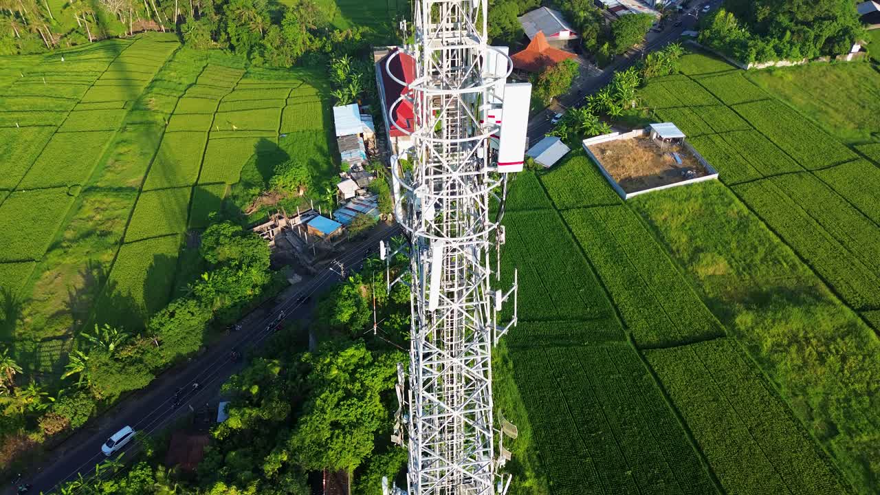 Rare Stunning Drone Aerial Climb Telecommunication Tower Wireless Internet WiFi 5G Above Countryside Landscape in Green Rice Fields during day in 4K