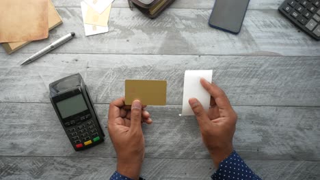 men holding a credit card and receipt on table ,