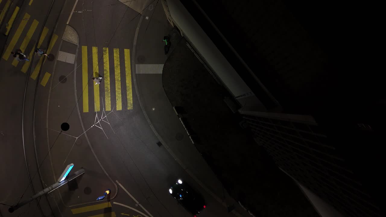 straight down aerial view of Zurich, Switzerland street with bus crossing at night