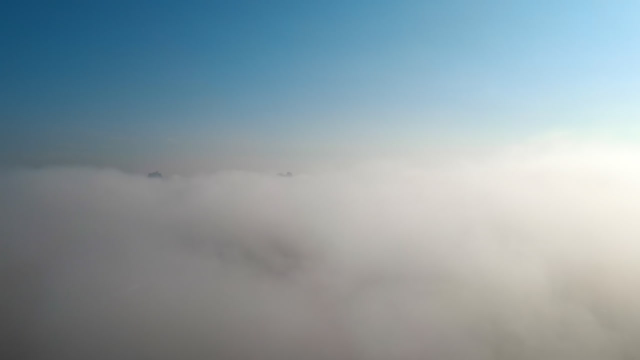 Aerial drone view above the clouds with buildings visible through, Chisinau, Moldova