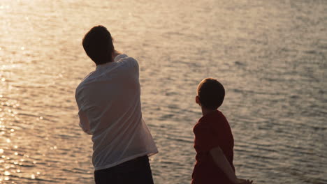 Father and Son Playing at Sunset by the River