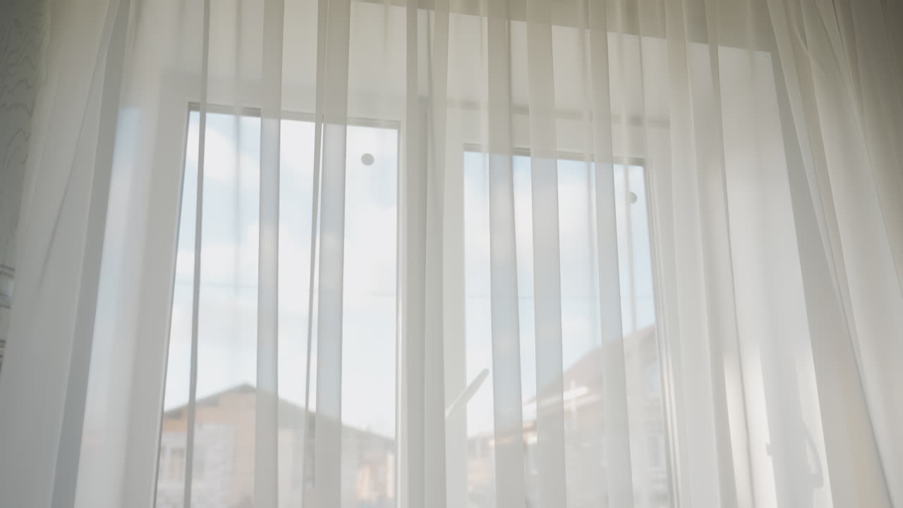 View of residential building seen through transparent white curtain from inside bright cozy kitchen morning sunlight softly filtering through sheer fabric