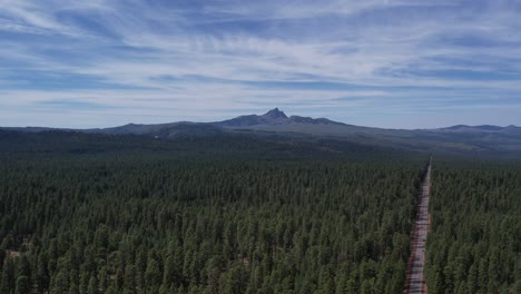 flying over a forest toward the mountain three fingered jack in central oregon