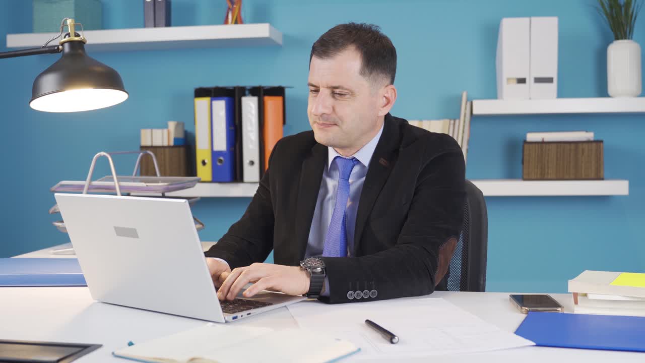 Uomo d'affari che lavora in ufficio usando il portatile in uno stato preoccupato e stressato