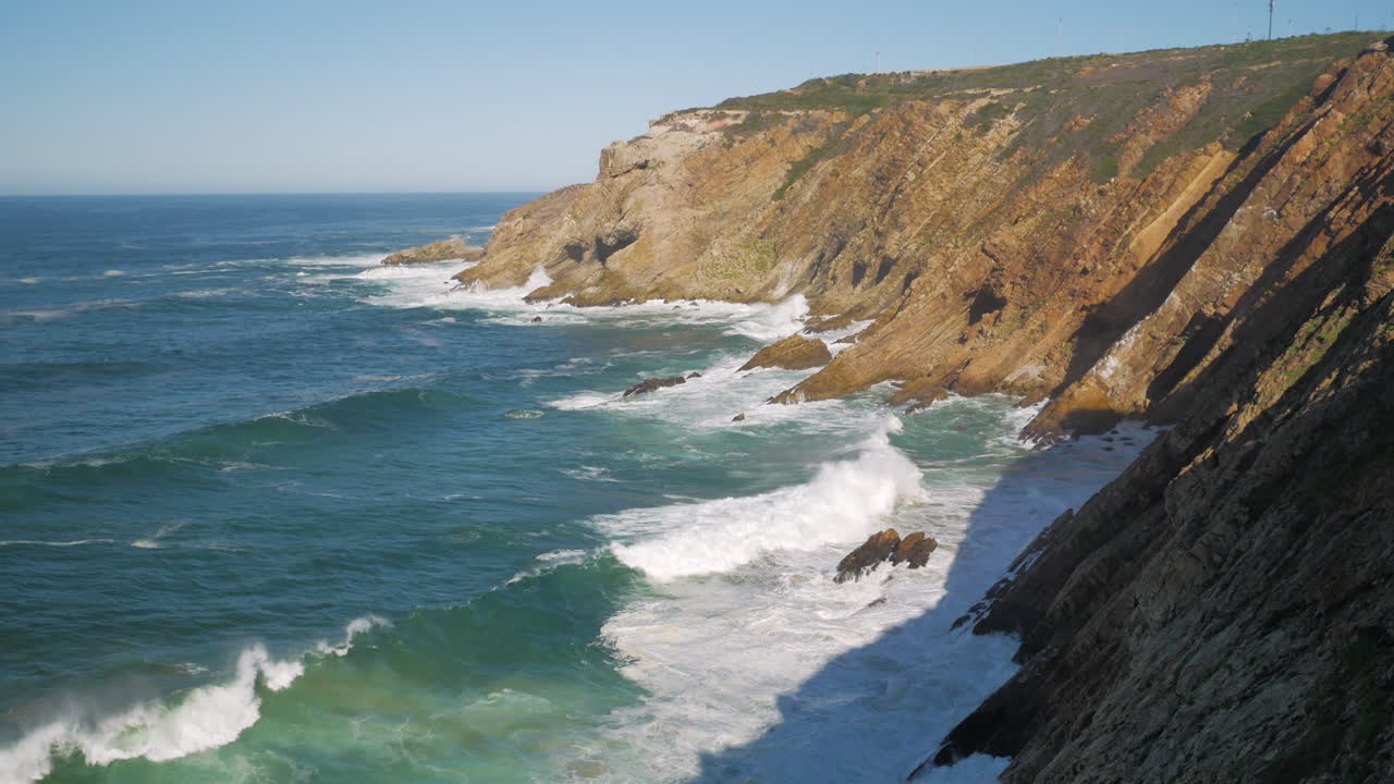 Tilt-up shot of waves crashing into cliffs of Mossel Bay, South Africa