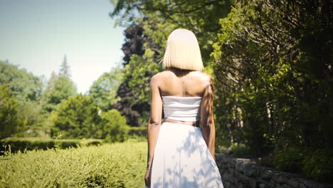 Elegant-woman-wearing-a-white-dress-walking-in-a-courtyard