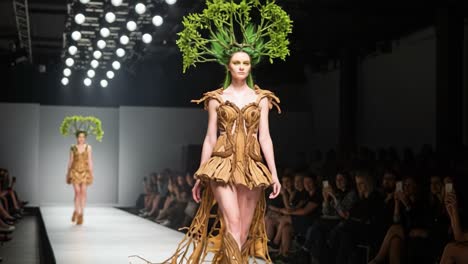 a stunning display of eco-fashion: model walks the runway in a unique tree-inspired design featuring natural materials and creative environmental themes