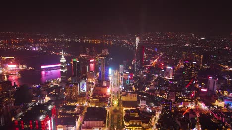 aerial: nguyen hue boulevard and cityscape at night in district 1, downtown ho chi minh city, vietnam, pull out drone shot