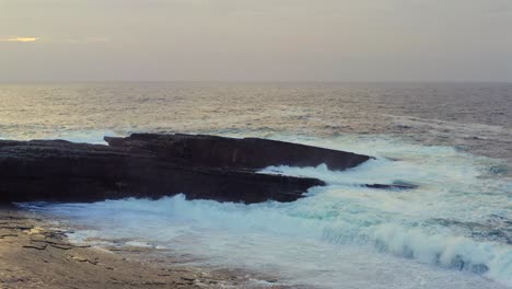sunset glow on the bridges of ross, calm sea and warm colors spread across the rock strewn peaceful coastal scene