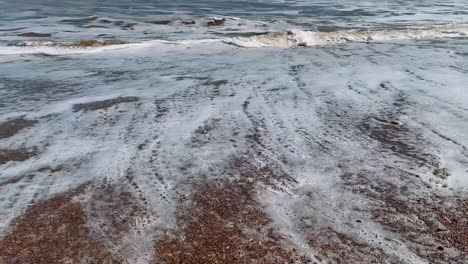 footprints in the sand washed away by the sea waves at the coast