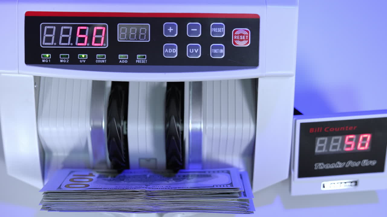 Money counting equipment for paper money calculation. Automatic mechanism for bank financial operations. Currency exchange of one hundred dollars. Close-up.