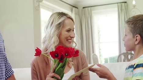 Hijo-Ofreciendo-Un-Ramo-De-Flores-A-Su-Madre-En-El-Salón.