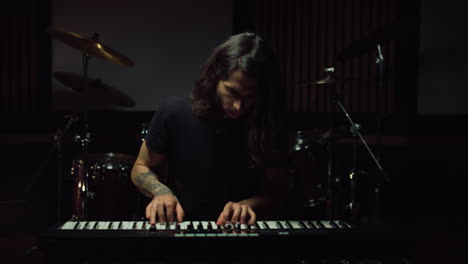 Man-playing-keyboard-in-music-studio.-Guy-smiling-in-recording-studio.