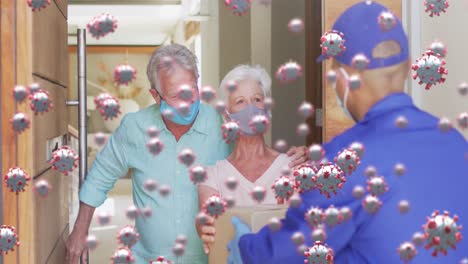 animation of covid cells over senior couple and delivery man in face masks