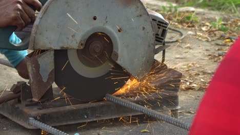 trabajador que corta una línea de metal con una sierra circular