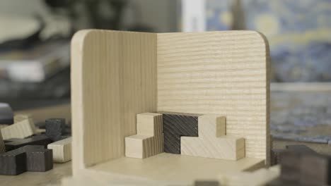 la mano construye un rompecabezas de cubos de madera en la mesa de cerca.