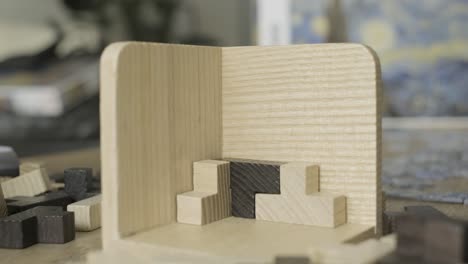 hand builds wooden cube puzzle on table close up