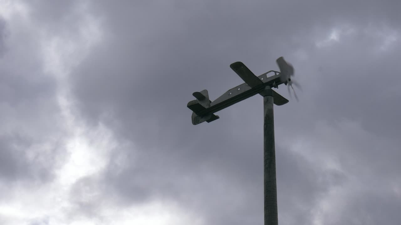 회색 구름 앞에서 바람과 함께 움직이는 비행기 풍향계