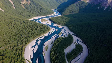 aerial view of a braided river winding through a forested mountain valley