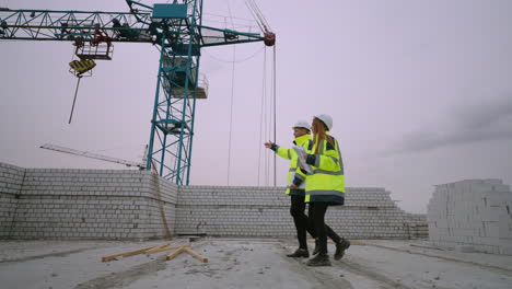 man and woman are walking in under-construction building civil engineers in construction site