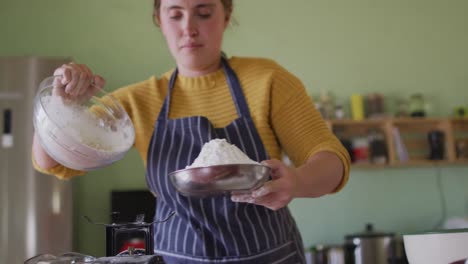 mujer caucásica enfocada horneando en la cocina