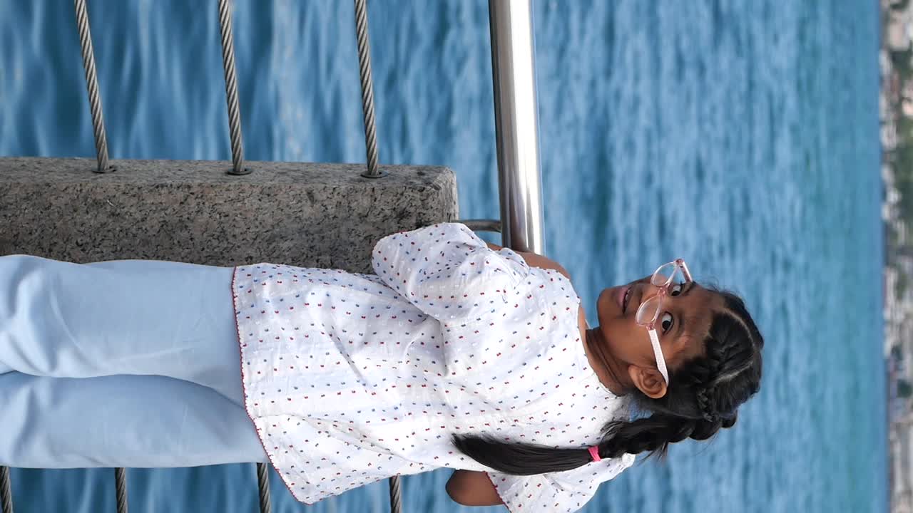 Girl Looking at the Ocean from a Bridge