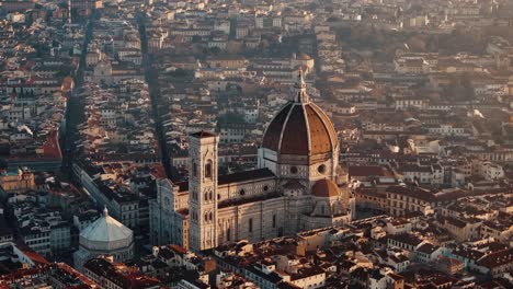 descending pan up of florence duomo bathed in warm sunrise light