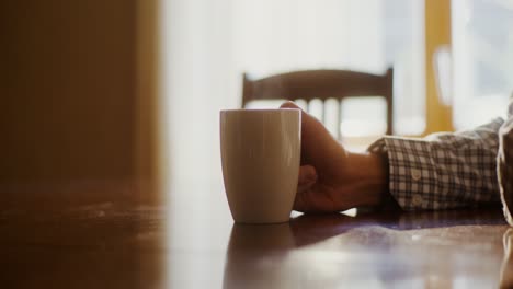 person relaxing at a table with coffee