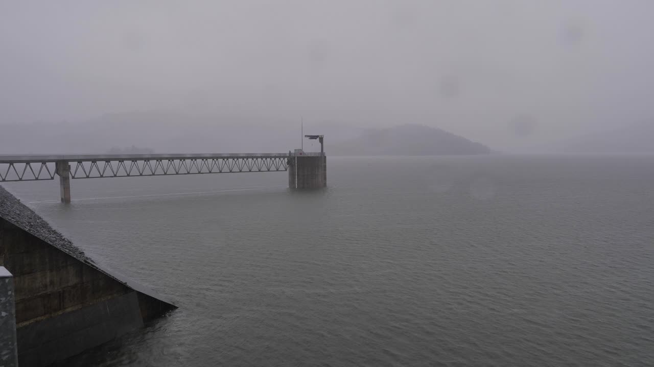 Handheld shot of Hinze Dam under heavy rain and water flows during La Ni&ntilde;a, Gold Coast Hinterland, Queensland, Australia