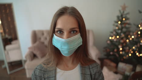 portrait of woman taking off the face mask looking at camera smiling indoors at home