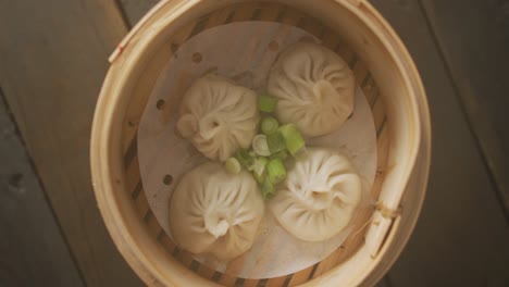 composición de vapor de bambú con dumplings de dim sum sobre un fondo de madera