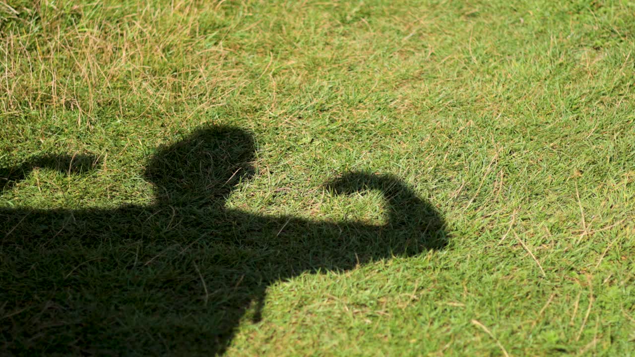 잔디에 팔을 구부리는 그림자