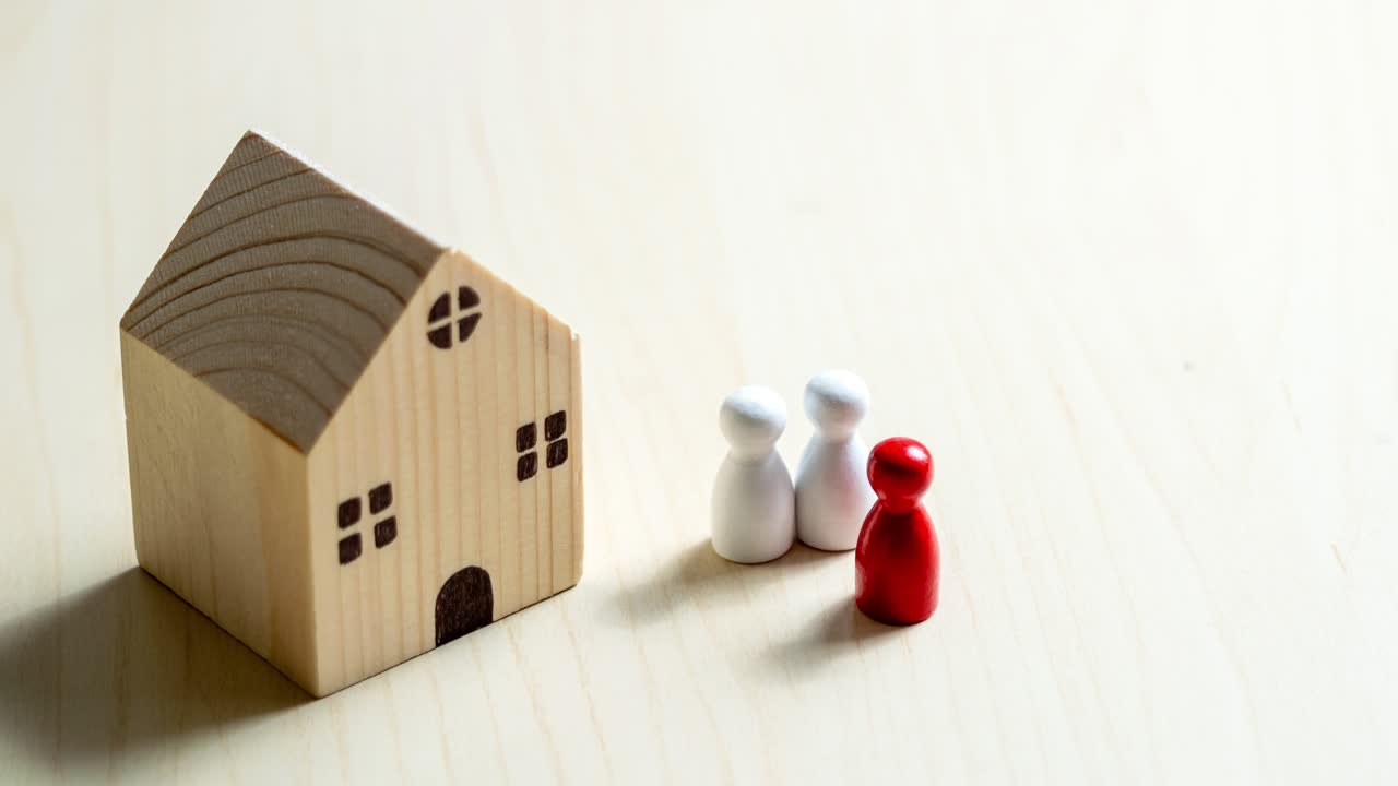 A close-up scene captures the essence of family dynamics around a miniature home.