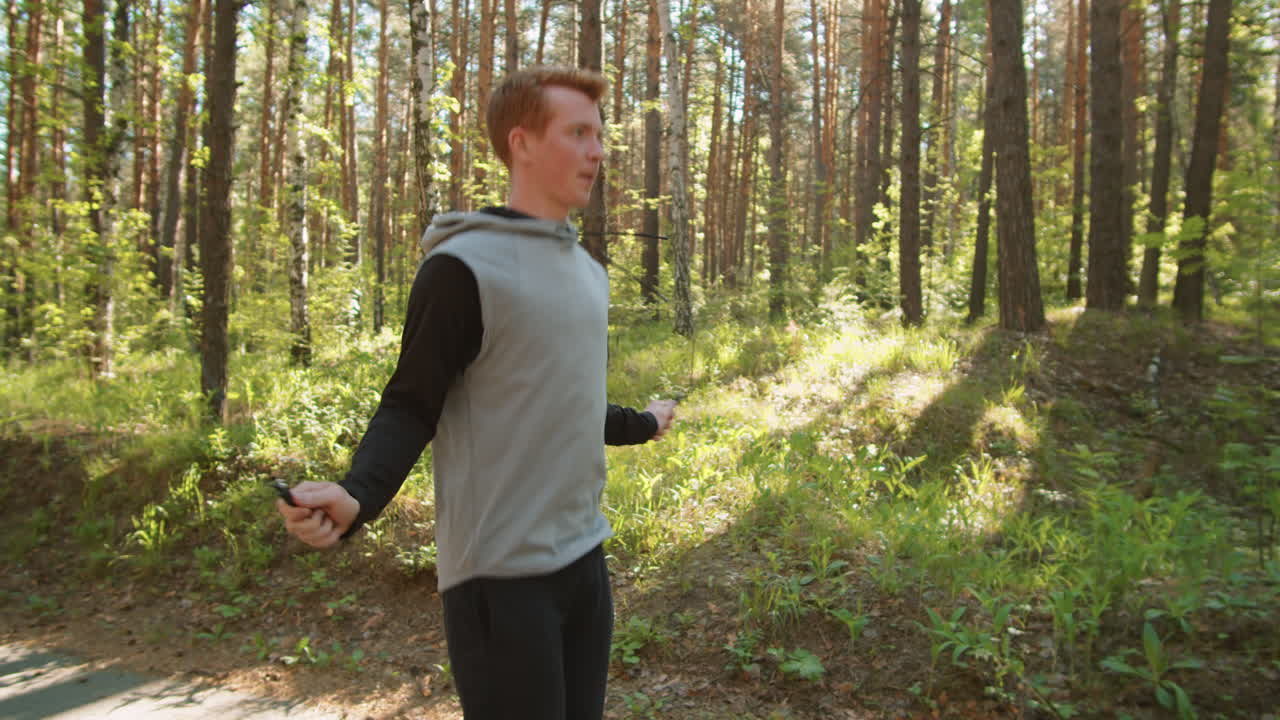 숲에서 로프를 뛰어넘는 남자