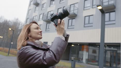 woman taking a photo of an apartment building