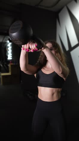 woman performing kettlebell exercises in a gym