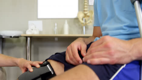 fisioterapeuta examinando la rodilla del paciente