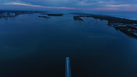 Boat-racing-to-beat-the-dawn,-stunning-sunrise,-Gold-Coast-Seaway,-Australia