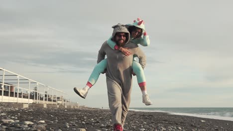 couple in animal costumes piggybacking on the beach