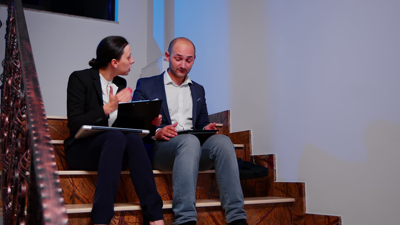 una mujer de negocios furiosa con un compañero de trabajo haciendo horas extras.