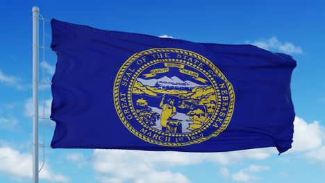 nebraska flag on a flagpole waving in the wind, blue sky background. 4k